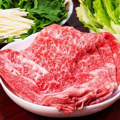 和牛セレブの松阪牛黒毛和牛すき焼き・しゃぶしゃぶ用500g、白い皿に盛り付けられた霜降りのモモ薄切り肉と新鮮な野菜