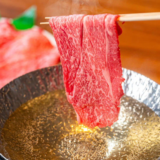 箸でつまんだ黒毛和牛の薄切り肉から湯気が立ち上り、しゃぶしゃぶ鍋の黄金色のだしに今まさに浸けようとしている躍動感あふれる一瞬