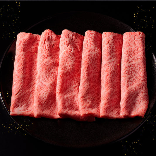 能登牛肩ロースのスライス6枚が黒い丸皿に扇状に広げられ、きめ細やかな霜降りと鮮やかな赤身が美しく映えている