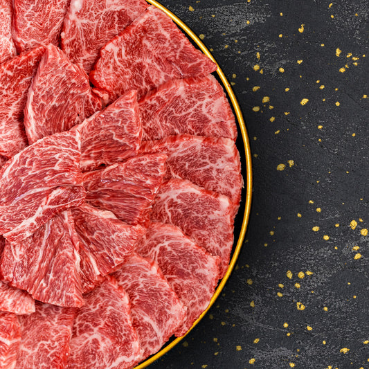 金縁の黒い皿に米沢牛肩ロースの焼肉用スライスが放射状に重ねられ、きめ細かな霜降りが際立っている