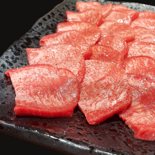 和牛セレブの焼肉用牛タン900gが黒い皿に並べられ、霜降りの入った鮮やかな赤身と白い脂肪が美しいマーブル模様を見せている