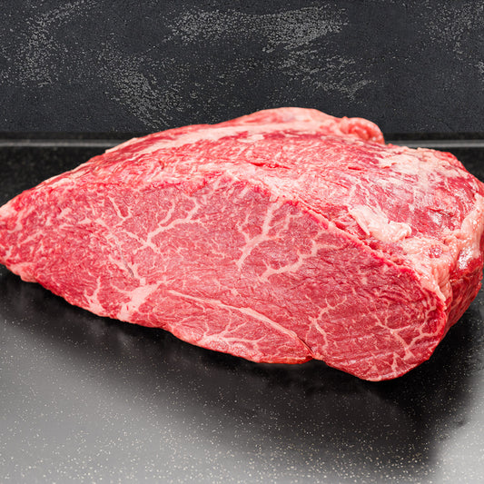 スレート調の黒い台に置かれた前沢牛ランプステーキの生肉。きめ細かな霜降りが全体に入り、赤身の引き締まった質感がわかるアングル