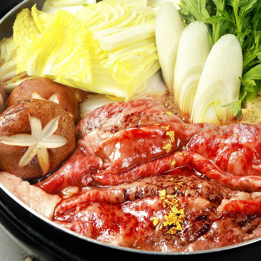 近江牛のブリスケスライスがすき焼き鍋の中で割り下に絡まり、白菜や椎茸などの野菜とともに食べ頃の状態に仕上がっている