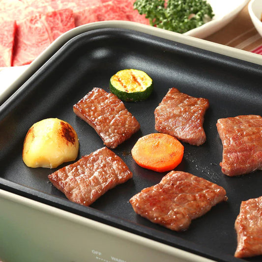 土佐黒牛のウデとバラを電気グリルプレートで焼いている場面、ズッキーニやにんじんなどの野菜と並んで均一に火が入った状態