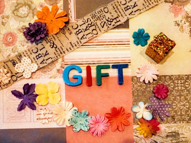 色とりどりの造花とカラフルなGIFTの文字が散りばめられた、贈り物のシーンを連想させるコラージュ装飾
