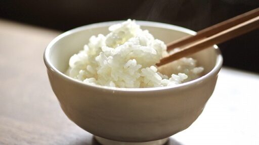 湯気の立ち上る白いご飯が茶碗に盛られ、箸が添えられているローファットダイエット向け主食のシーン