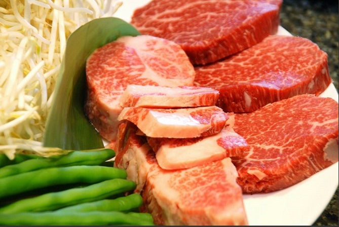 美しい霜降りの和牛赤身ステーキ肉が白い皿に盛られ、もやしとアスパラガスが添えられている