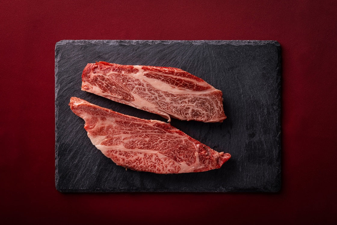 黒いスレートボードに並べられた霜降りの和牛赤身肉2枚。きめ細かい脂肪交雑が全体に広がり、ダイエットで注目されるL-カルニチンを豊富に含む引き締まった赤身が特徴的