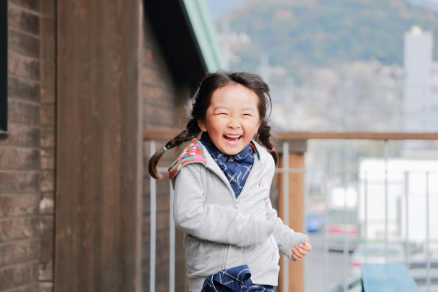 白いパーカーを着た女の子が笑顔で走り回り、ハンバーグギフトを受け取った家族の喜びを表現している
