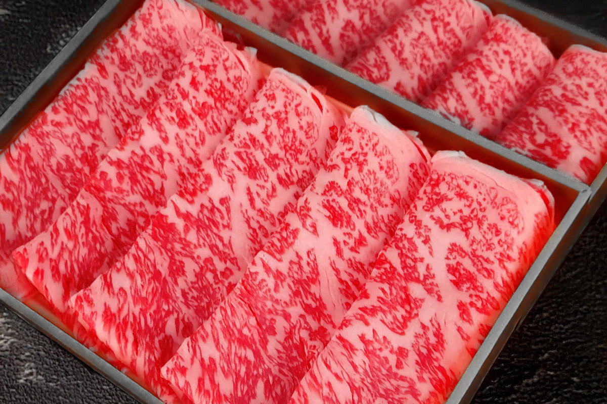 折箱に並んだ松阪牛のすき焼き用薄切り肉。きめ細かな霜降りが入っている