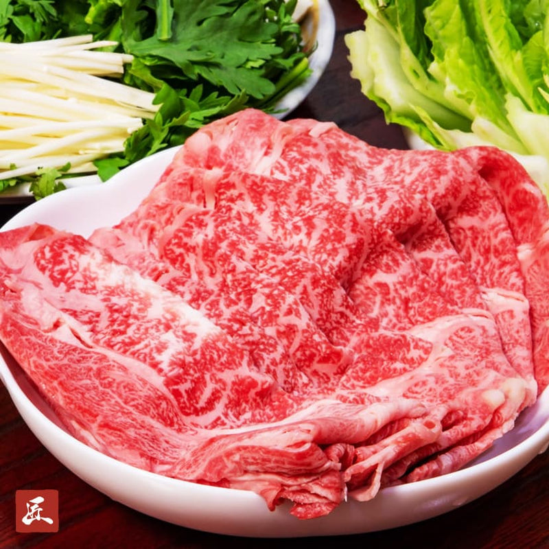 和牛セレブの松阪牛肩ロースを薄くスライスした霜降り肉が白い皿に盛られ、水菜や三つ葉などの野菜を添えたすき焼きしゃぶしゃぶ用の一皿