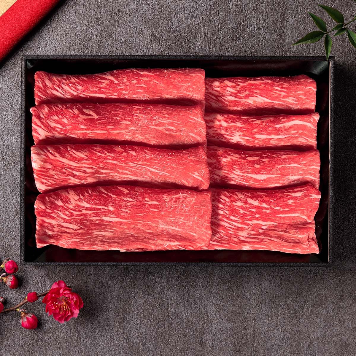 和牛セレブの神戸牛モモすき焼き用200gが黒トレーに整然と並び、赤身と霜降りが織りなす美しい断面を見せている