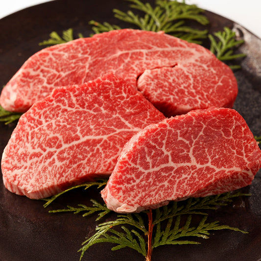 飛騨牛カイノミのステーキ用生肉3枚をクローズアップで撮影し、鮮やかな赤身に白い霜降りが均一に広がる断面の美しさが際立っている