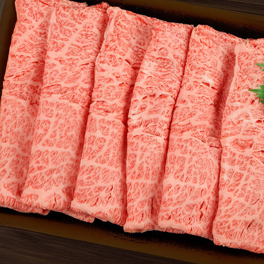 飛騨牛肩ロースの薄切りスライスを真上から撮影し、細かい霜降りと赤身のコントラストが鮮明に映し出されている