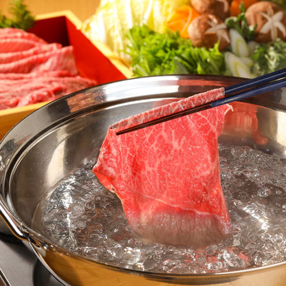 飛騨牛しゃぶしゃぶの薄切り肉が箸でつままれ沸騰した鍋の湯にくぐらされる瞬間を正面から捉えた場面