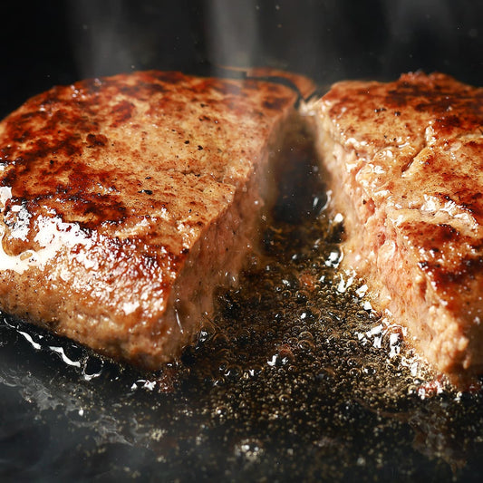 飛騨牛ハンバーグ2個が鉄板の上で肉汁をしたたらせながら黄金色に焼き上がっているアップショット