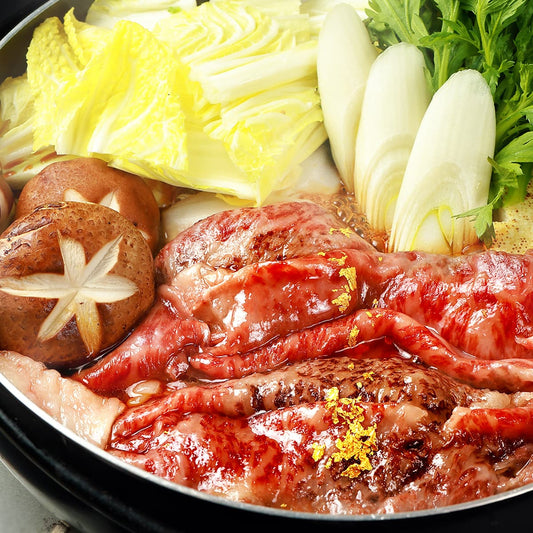 仙台牛 肩ロースのすき焼きが黒鍋で煮えており、割り下に絡んだ霜降り和牛と金箔のトッピング、白菜・ネギ・椎茸が添えられている