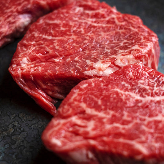 前沢牛イチボの生肉を間近で捉えたカット、鮮やかな赤身に細かく均一なサシが全面に入りしっとりとした肉質が際立っている