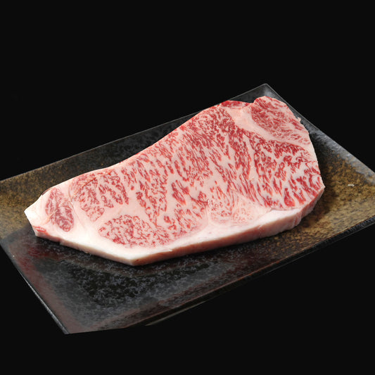 宮崎牛特上ロースステーキ用150g 黒い和皿に盛られたきめ細かい霜降りが均等に広がる生肉のアップ