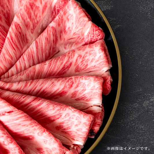 黒いプレートに扇状に広げられた肩ロースのスライスで細かなサシが均一に入った断面のクローズアップ