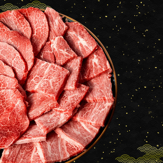 丸い黒い皿に盛られたカタロースとウデの焼肉用スライス、鮮やかな霜降りと引き締まった赤身が混在し断面のコントラストが際立つ