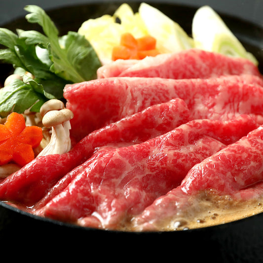 前沢牛のすき焼きスライスを黒鍋で割り下に浸した調理シーン きのこや野菜とともに盛り付けられた食卓