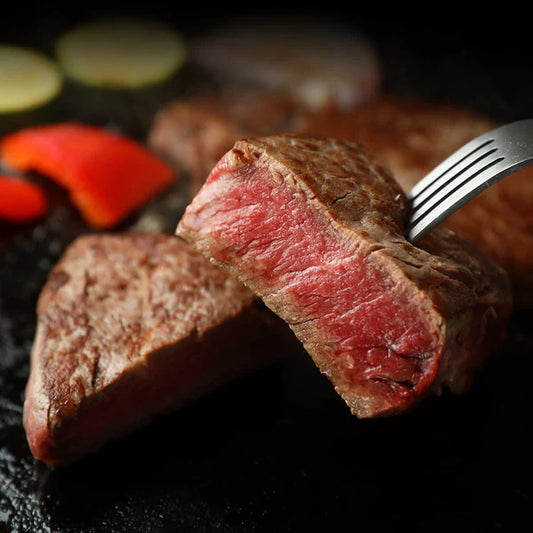 フライパンで焼き上げた近江牛ランプステーキをフォークで持ち上げ断面の鮮やかな赤身とジューシーな焼き色が際立っている